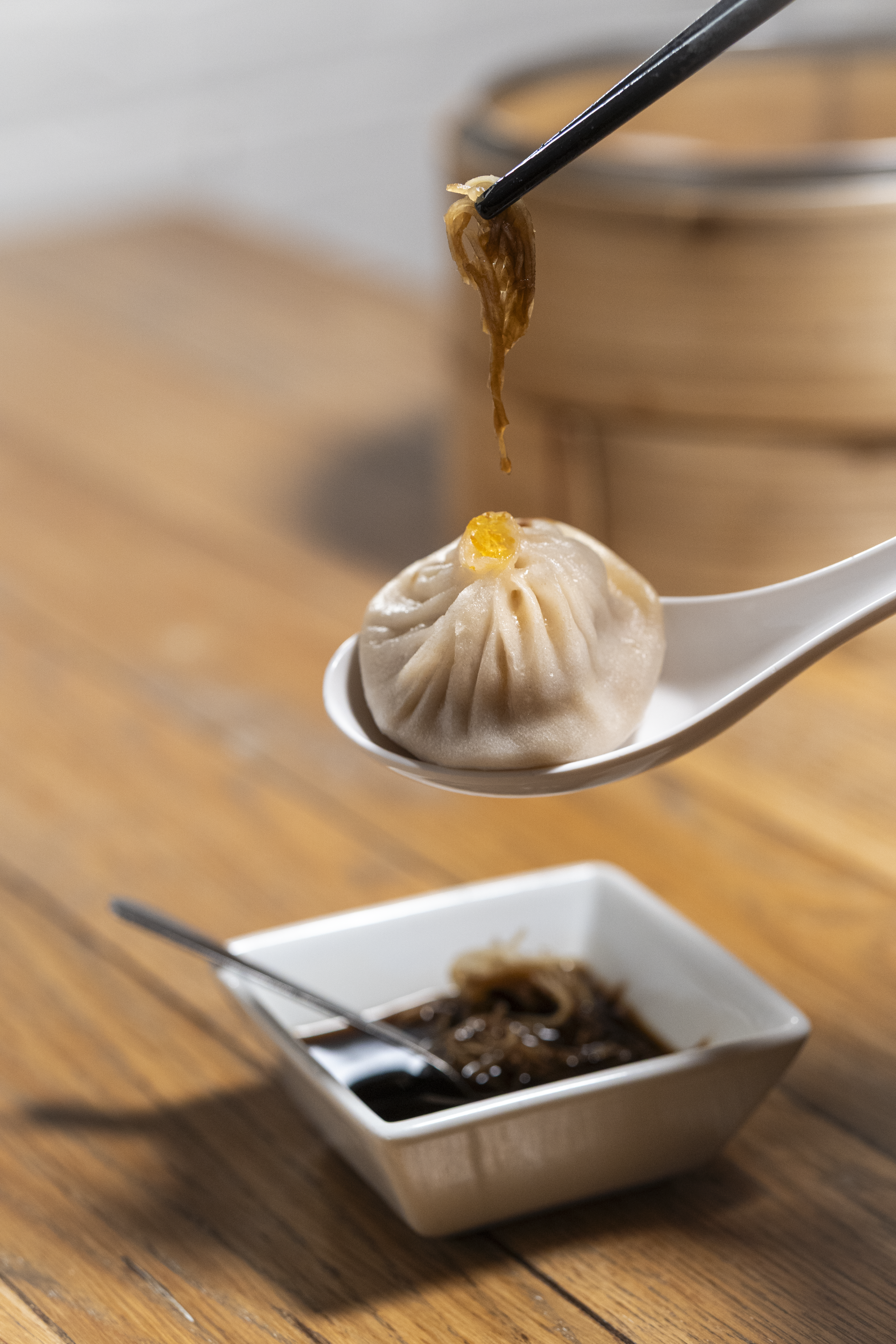 xiao long bao on a spoon with broth